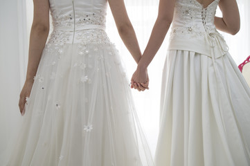 From behind of two people of the bride wearing a wedding dress
