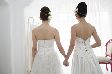 From behind of two people of the bride wearing a wedding dress