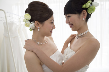 Two brides are hugging each other