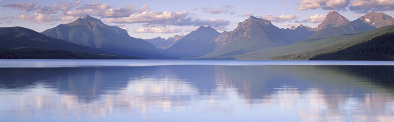 This is Lake McDonald. The surrounding mountains are reflected in the lake. - obrazy, fototapety, plakaty