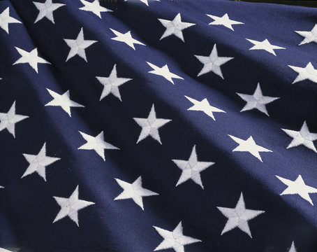 These are the stars of the American flag. They are against their blue field, climbing upward toward the corner of the image as if they were situated on small stairs that move up in levels..