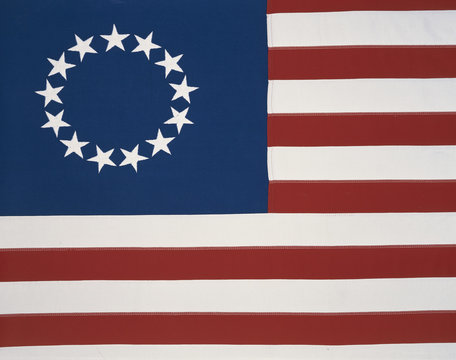 This is the original colonial flag with 13 stars representing the 13 original states at the time of the American Revolutionary War. The 13 stars are against a field of blue and the red and white stripes are sitting flat and move horizontally.