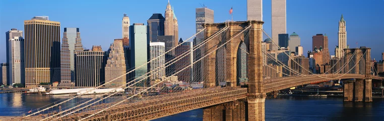 Foto op Plexiglas Dit is een close-up van de Brooklyn Bridge over de East River. De skyline van Manhattan is erachter bij zonsopgang. © spiritofamerica