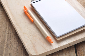 blank note paper and orange pencil on block.