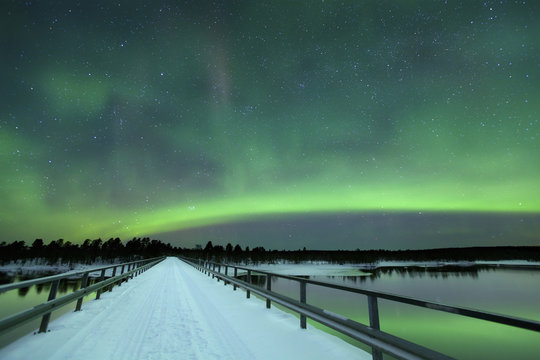 Aurora borealis over a bridge in winter, Finnish Lapland