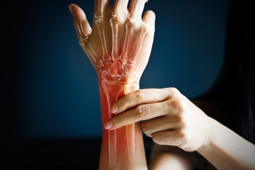 Acute pain in a woman wrist, colored in red on dark blue background - obrazy, fototapety, plakaty
