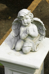 Fototapeta na wymiar close up cement cherub doll in garden