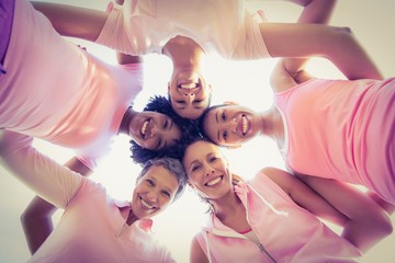Women wearing pink for breast cancer with arms around
