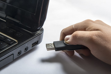 Hand inserting usb memory stick to laptop computer