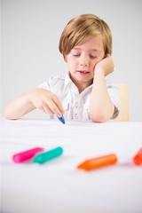 Composite image of cute boy colouring