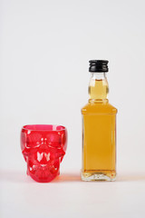 red skull and whiskey on white table