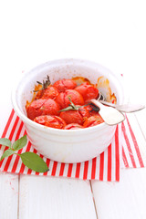 baked cherry tomatoes in a white ceramic form