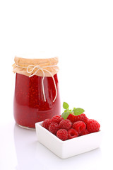 jar with raspberry jam on a white background