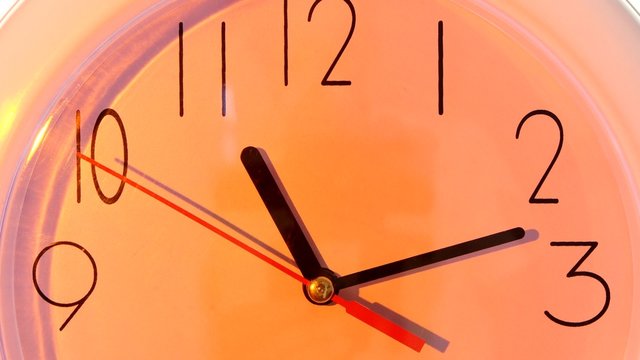 isolated orange clock. close up, hours day