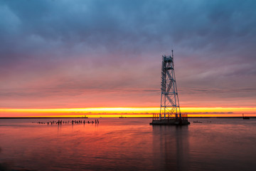 Obraz premium Lighthouse at dramatic Baltic sunset