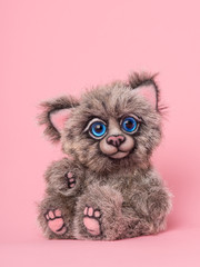 Cute fuzzy teddy bear stuffed animal toy sitting on a pink background