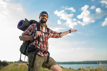 Naklejka premium Young caucasian man with backpack standing on the top of hill