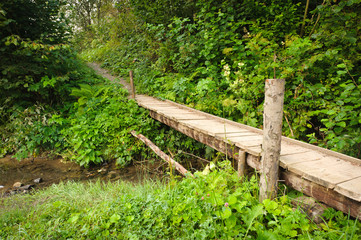 Landscape with a wooden bridge over a river 