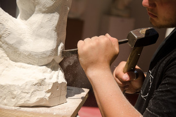 Man with hammer working on stone statue