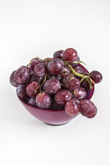 Fresh red grapes in a purple bowl