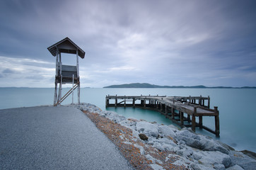 Old cottage and pier are near road.