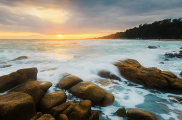 Fototapeta na wymiar Wave hit rock in sunset time seascape.