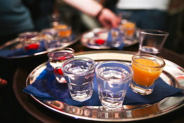 Several shot glasses on silver tray