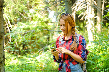  Hiker young girl searches GPS coordinates on smartphone .
