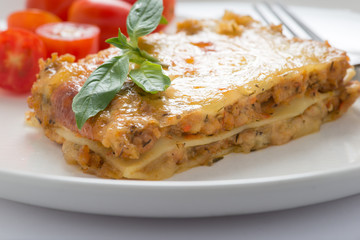 fresh lasagna with basil on white background