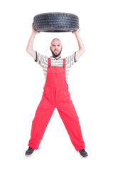Mechanic lifting a car wheel above head