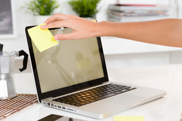 Woman hand stick a remember in the computer screen