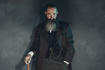 Mysterious vintage beard man in 1900 style fashion with cane aga