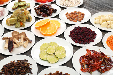 Different products on saucers on wooden table, closeup