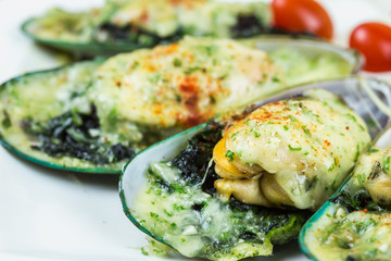 Mussels under cheese on wooden table