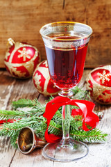 Red sparkling wine in the glass, tree branches, Christmas tree b