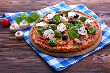 Tasty pizza with vegetables and basil on table close up