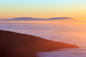 Aerial view over clouds above ocean water with last sunshine, Tenerife, Canary Islands, Spain
