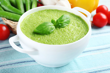 Tasty peas soup and vegetables on table close up