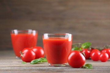 Glasses of tomato juice with vegetables on wooden table close up