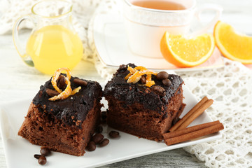 Cake with Chocolate Glaze and orange on plate, on wooden background
