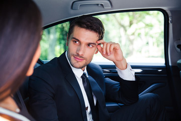 Business couple talking in car