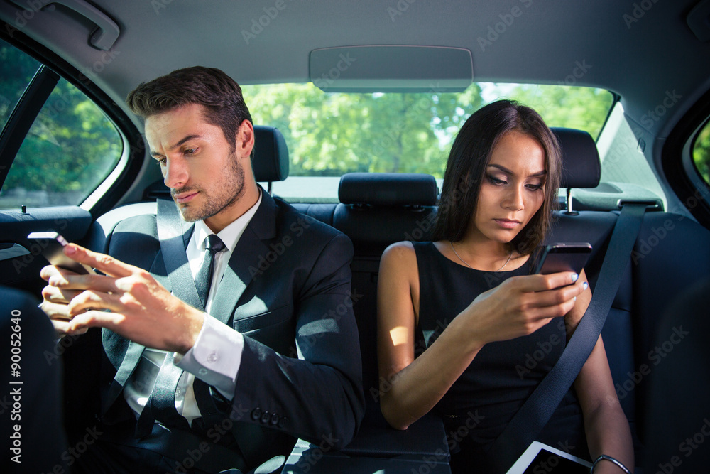 Sticker businessman and businesswoman using smartphone in car