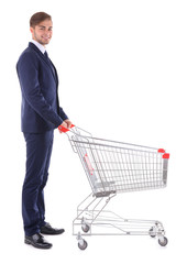 Young man with empty shopping cart, isolated on white