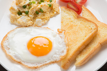 fresh fried egg and scrambled egg with bread for breakfast