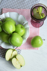 Fototapeta na wymiar Green apples in bowl on table with napkins, closeup
