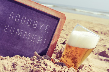text goodbye summer in a chalkboard and a glass of beer on the b