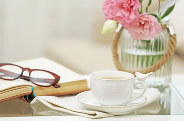 Cup of coffee with book on table in living room
