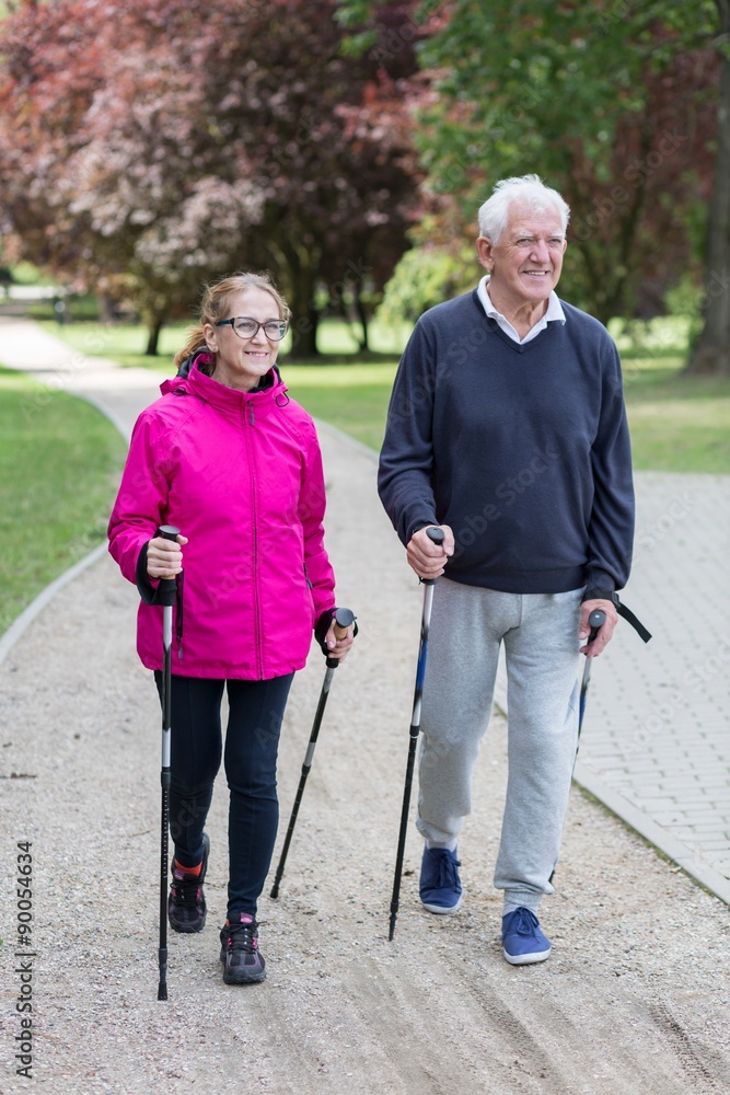 Poster Elderly couple doing nordic walking