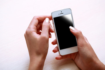 Woman using mobile phone on workplace close up