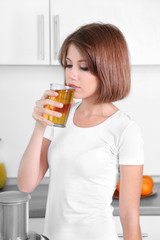 Young beautiful woman drinking apple juice